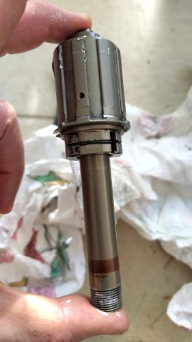 Hand holding a bike hub axle with freehub on it