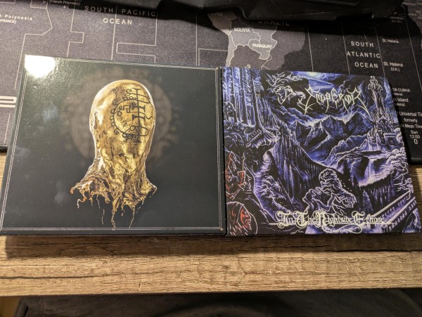 Zdjęcie dwóch płyt z muzyką blackmetalową - Gaerea i "Mirage" (złota płachta na twarz z rytualnymi znakami na czarnym tle) oraz Emperor i ich "In The Nightside Eclipse" (biało-czarno-niebieska sceneria nad górami i zamkiem, gdzie widać nieczyste moce)