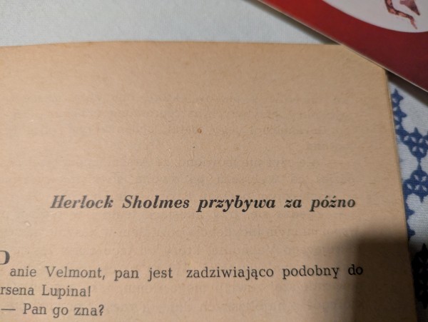 Zdjęcie tytułu rozdziału w książce: "Herlock Sholmes przybywa za późno". Poniżej widać we fragmencie tekstu, że to książka o Arsene Lupinie.