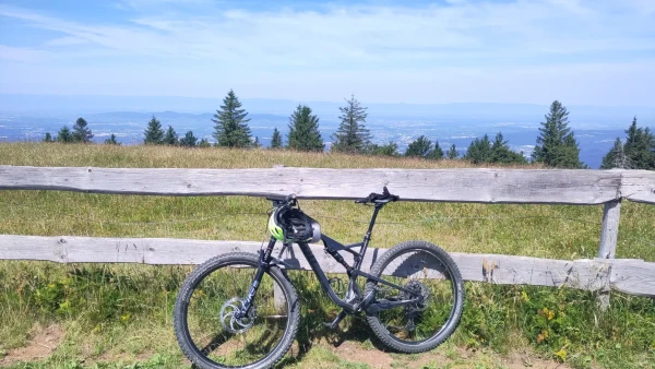 Ein MTB lehnt auf dem Kandel an einem Hoßzzaun. Dahinter eine Wiese und Ausblick in den umliehenden Schwarzwald