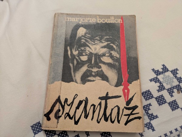 Okładka książki "Szantaż" Marjorie Boulton ze stylizowanymi literami pisanymi czerwonym piórem i niepokojącym zdjęciem mężczyzny, który coś knuje.