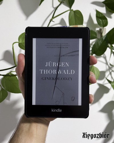 Zdjęcie czytnika Kindle wyświetlającego okładkę książki "Ginekolodzy" Jurgena Thorwalda.
