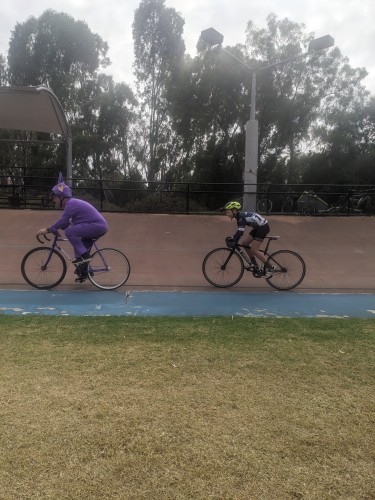 Tinky Winky leading his son in a team pursuit on a velodrome.