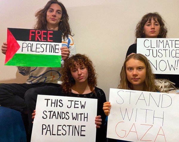4 young women posing with pro-Palestinian posters
