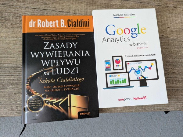Zdjęcie książek: "Zasady wywierania wpływu na ludzi" Roberta B. Cialdiniego oraz "Google Analytics w biznesie. Wydanie II" Martyny Zastrożnej.