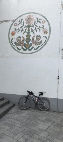 Rower oparty o ścianę, na ścianie mural z łowickim wzorem