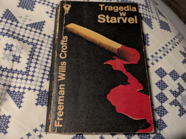 Zdjęcie okładki książki "Tragedia w Starvel" autorstwa Freemana Willsa Croftsa. Na okładce jest zapałka z czerwonym śladem na czarnym tle.