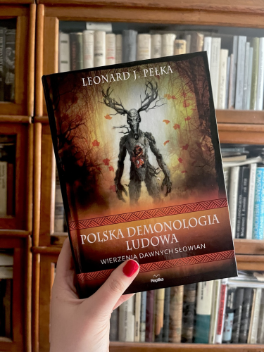 Okładka książki „Polska demonologia ludowa” z Leszym na tle jesiennego lasu. 