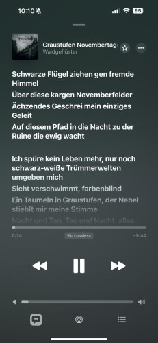 Odtwarzacz audio wyświetlający utwór “Graustufen Novembertage” z tekstem w języku niemieckim. Interfejs pokazuje elementy sterujące odtwarzaniem i wskazuje czas trwania utworu oraz ustawienia jakości.