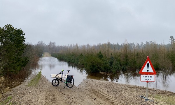 A flooded road and a bicycle just on the edge.