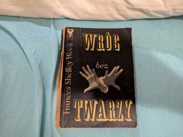 Okładka książki "Wróg bez twarzy" autorstwa Frances Shelley Wees. Okładka jest podniszczona, czarna, z dłońmi wyciąganymi w kierunku czytelnika.