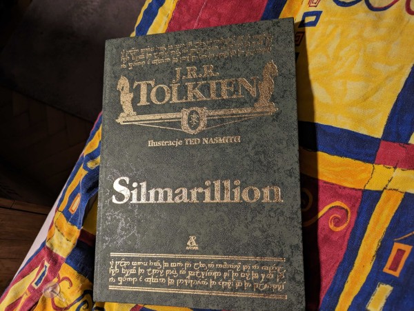 Zdjęcie okładki pięknie wydanego "Silmarilliona" J.R.R. Tolkiena z ilustracjami Ted Nasmitha. Okładka jest zielona, gruba, chropowata, wypukła, a litery (zarówno te normalne, jak i elfickie) złote. 